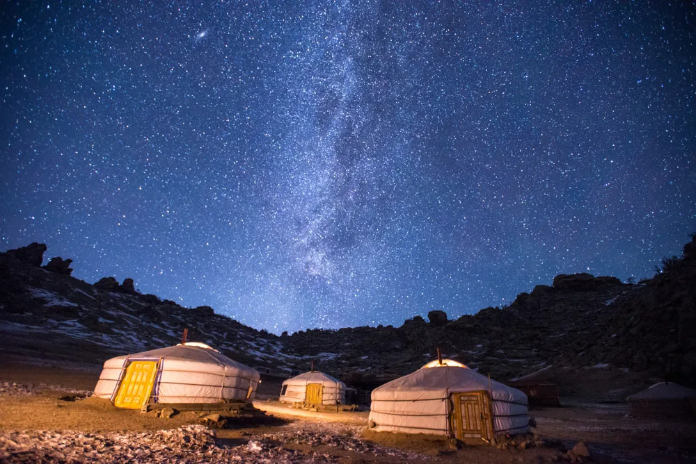 Yurts pictured at night with a gorgeous starry sky with millions of stars, as seen during the best time to visit Mongolia