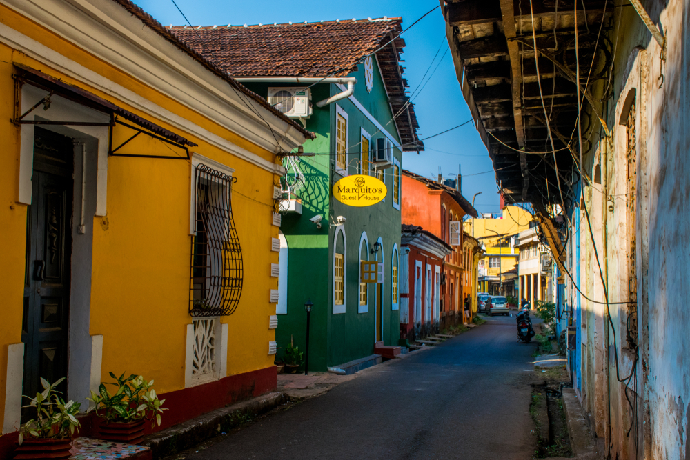 Small town village of Goa pictured during the best time to visit with colorful shops along a narrow street