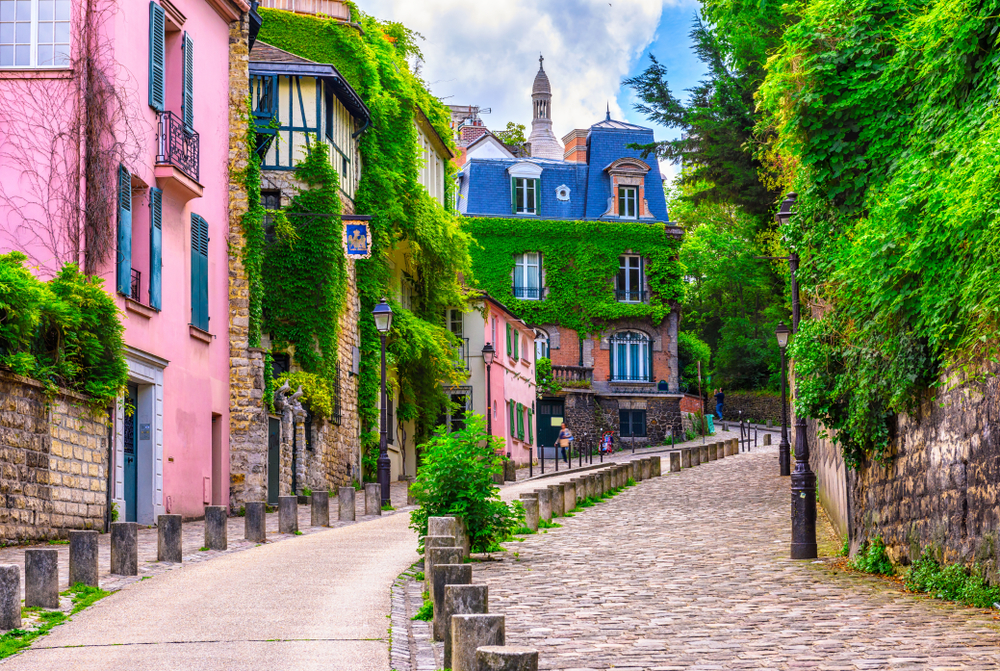 Neat buildings in the quarter of Montmartre in Paris, as seen on a clear day with vines covering the buildings, pictured for a piece titled is France safe to visit