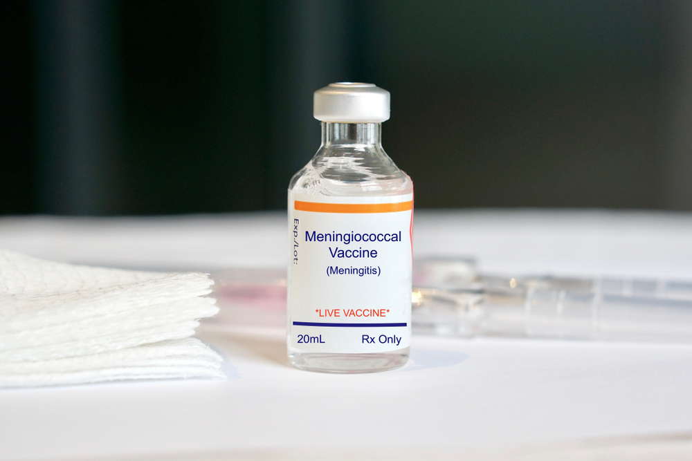 Meningococcal vaccine ciao with syringe lying behind it on a white counter for a piece on vaccines needed to travel to Africa