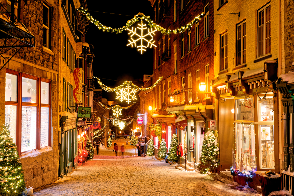 Picturesque little street in Quebec City, one of the best places to visit in December, with Christmas lights strung above the walkway