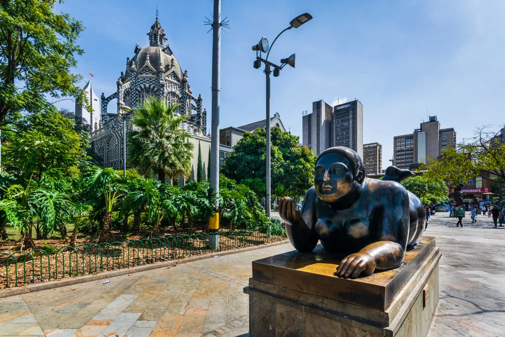Close-up shot of a statue in Botero Square pictured during the best time to visit Medellin, with blue sky and warm and dry air