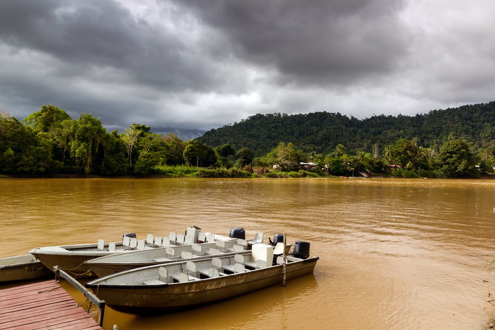 Rain clouds above a chocolate colored river in Laos