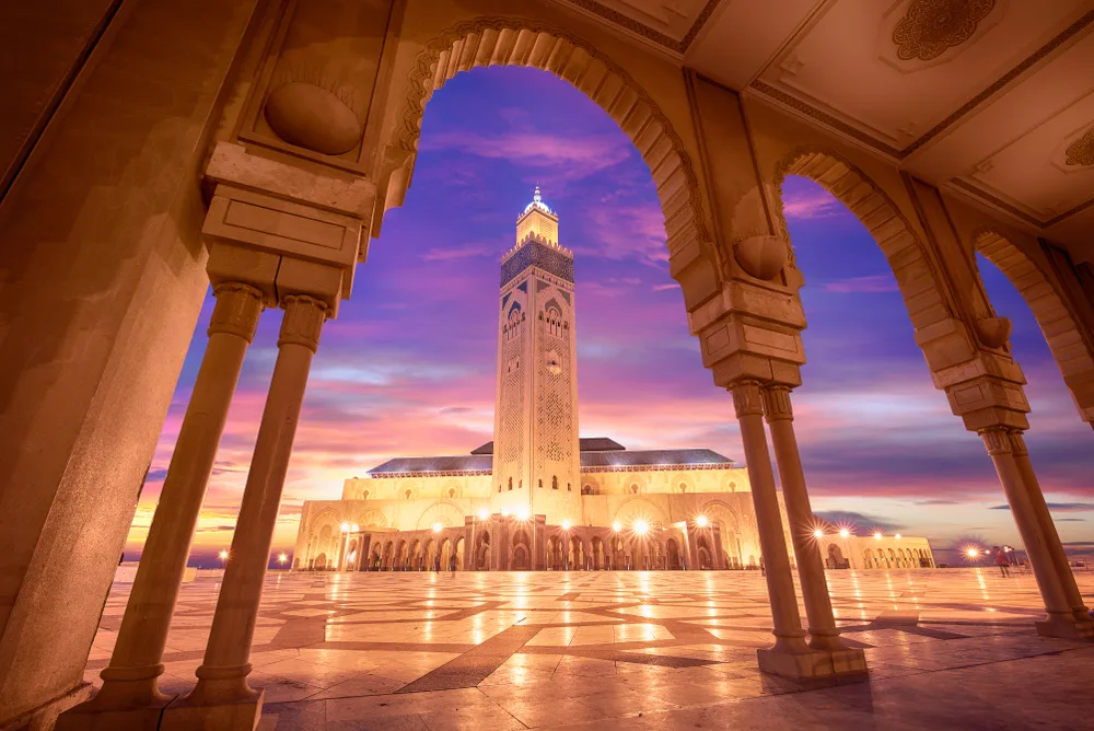 Night view of the mosque at Casablanca, as seen from a walkway between the arches, for a piece on the best places to visit in Morocco