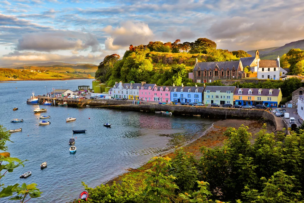 Neat view of the little fishing town in Skye, Scotland, one of the best places to visit in July, with colorful homes overlooking the bay