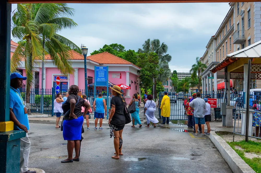 Rain falling on tourists wearing ponchos pictured during the worst time to visit Nassau