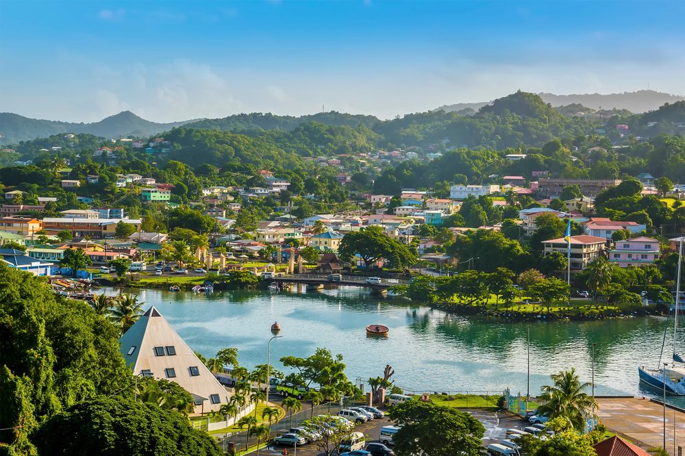 Aerial view of a waterway through Castries, Saint Lucia with boats and buildings poking through the lush greenery in springtime