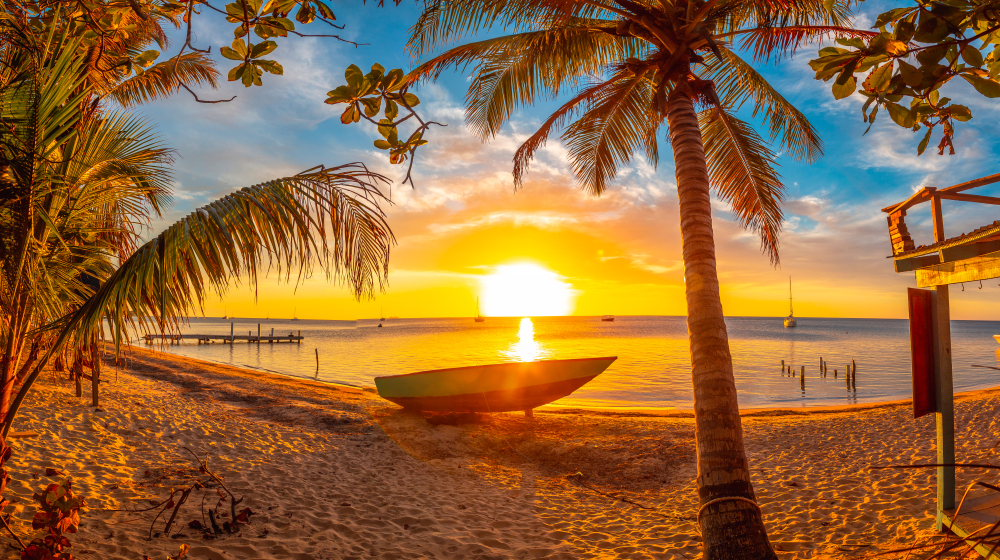 Neat view of a sunset over West End Beach pictured during the best time to visit Roatan