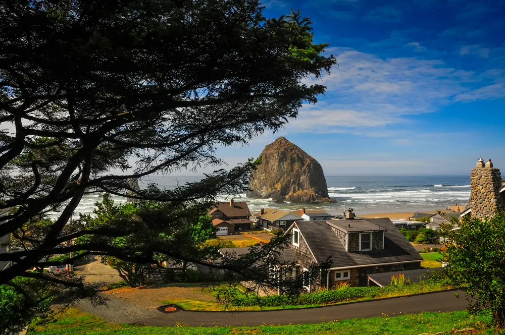 Photo taken from the top of the hill looking out over the ocean above houses for a guide titled Best Time to Visit Cannon Beach