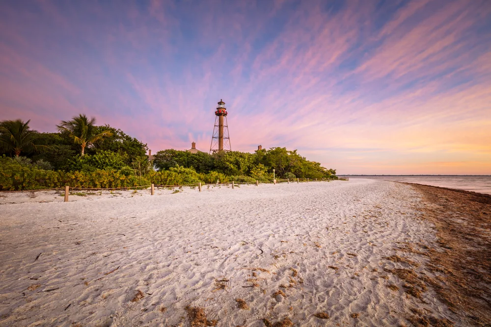 Idyllic view of the lighthouse in Sanibel, one of the best places in Florida to visit for couples, as seen at dusk with an orange and red sky