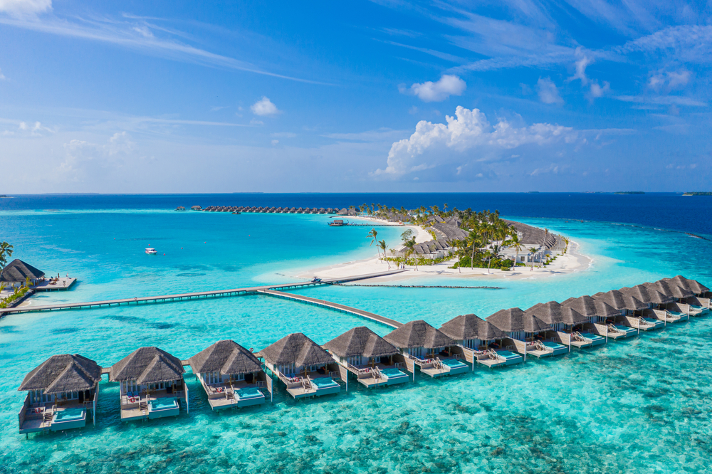 Rows of over-water bungalows above teal water in the Maldives, one of the best places to visit in January