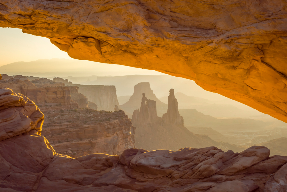 Breathtaking view of the Mesa Arch as seen from under the rock formation looking out toward the canyon in Moab, one of our top picks for places to visit in April