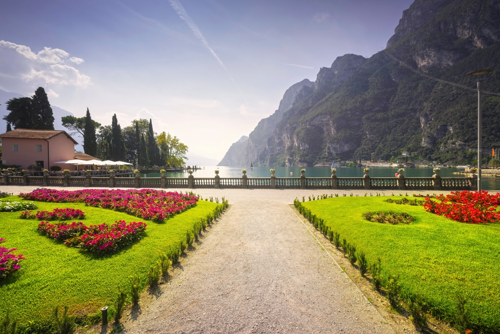 Gorgeous gardens alonside Riva del Garda in Trentino pictured during the best time to visit Italian Lakes