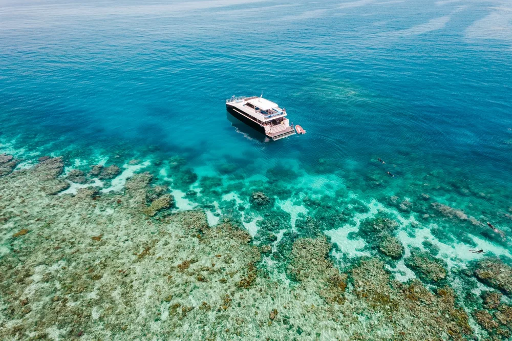 Aerial view of a dive boat above the Great Barrier Reef pictured during the spring, the best time to visit