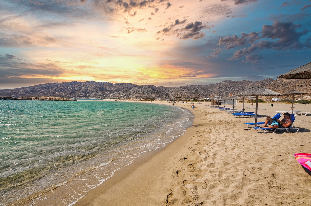 Expansive beach in Greece pictured at dusk with hardly anyone on it