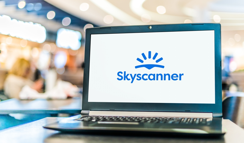Laptop showing the blue Skyscanner logo as the overall choice among the best websites to book flights
