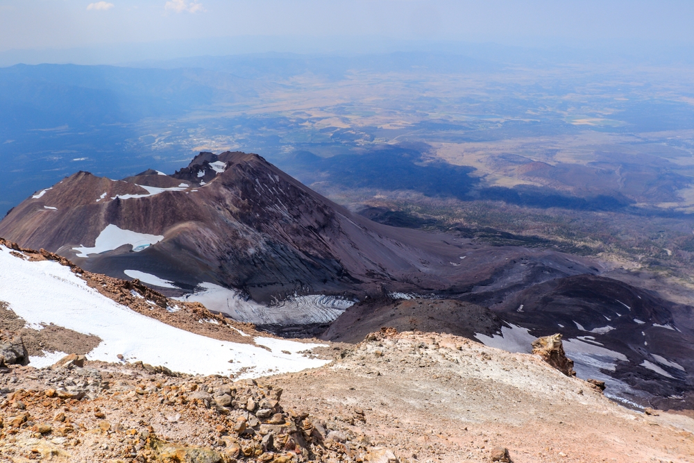 View from the top of Mount Shasta pictured during the best time to visit with haze in the background