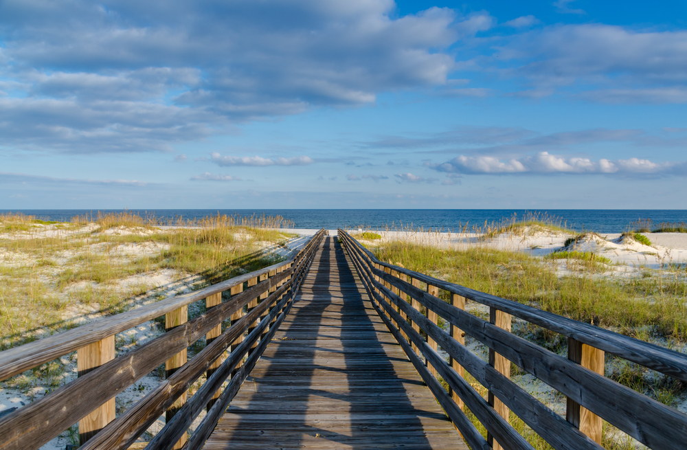 Wooden walkway to the beach in Gulf Shores Alabama pictured during the least busy time to visit with nobody in sight