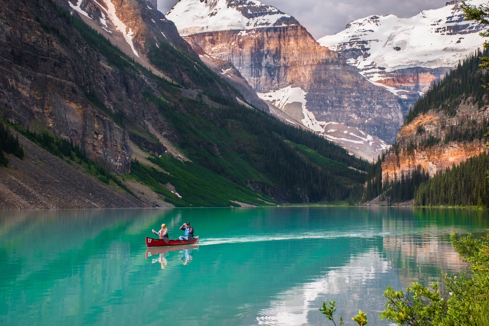 People in a canoe on a lake during the summer, the overall best time to visit Lake Louise