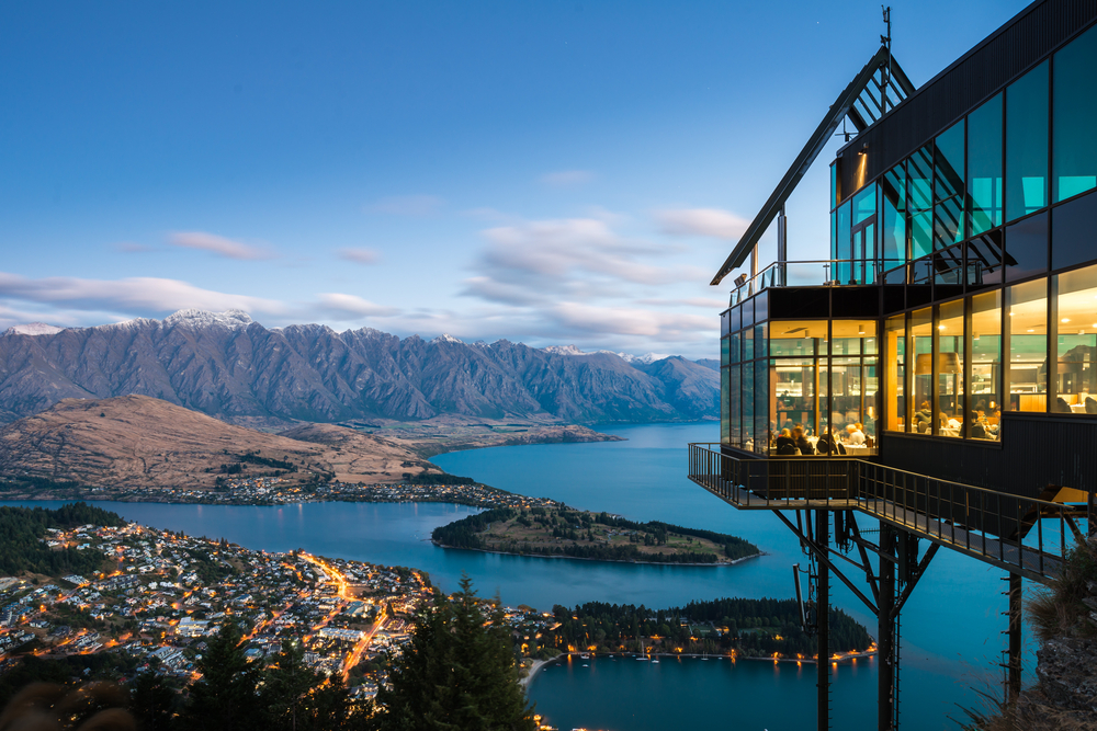 Glass and metal restaurant overlooking the bay in Queenstown, as seen from the outside at night