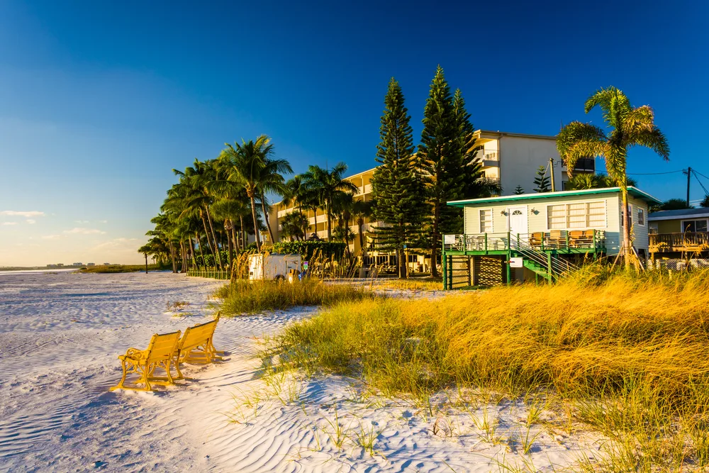 Neat building and hotel overlooking a white sand beach with blue skies above during the best time to visit Fort Myers, Florida