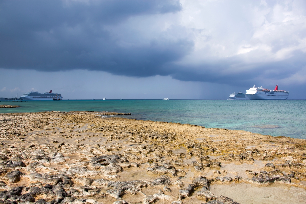 Several large cruise ships docked off the coast of Seven Mile Beach in Grand Cayman during hurricane season, the worst time to visit