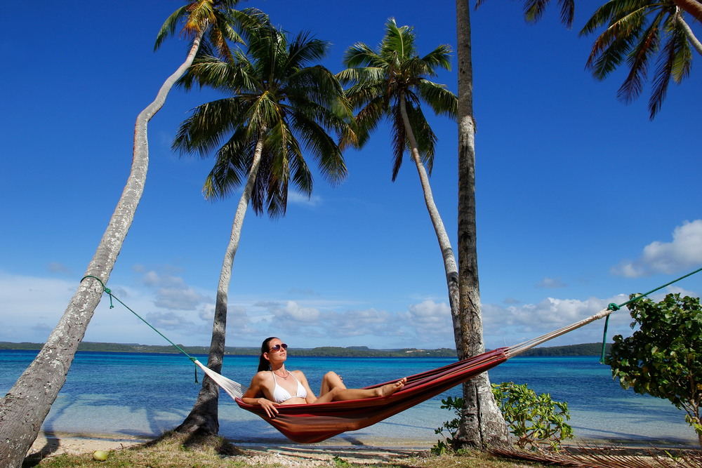 Woman in a white bikini lounging in a hammock in Tonga