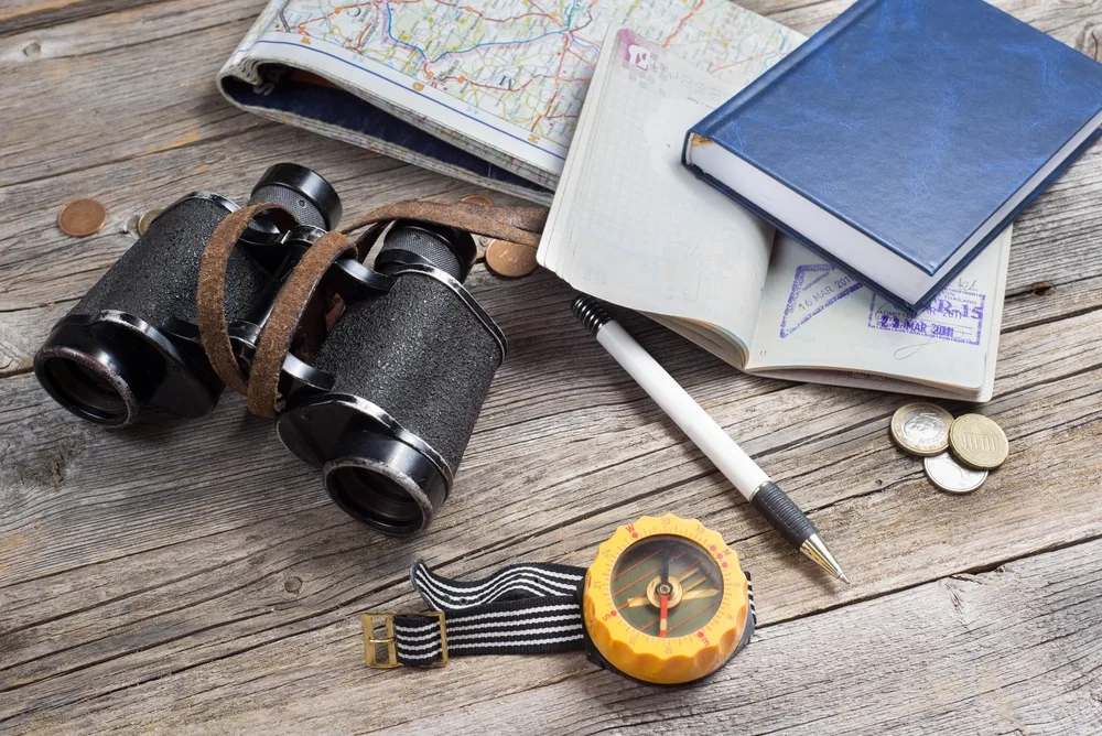 Items to pack with binoculars, compass, journal, and maps for a safari trip for a piece on the best time for a Tanzanian safari