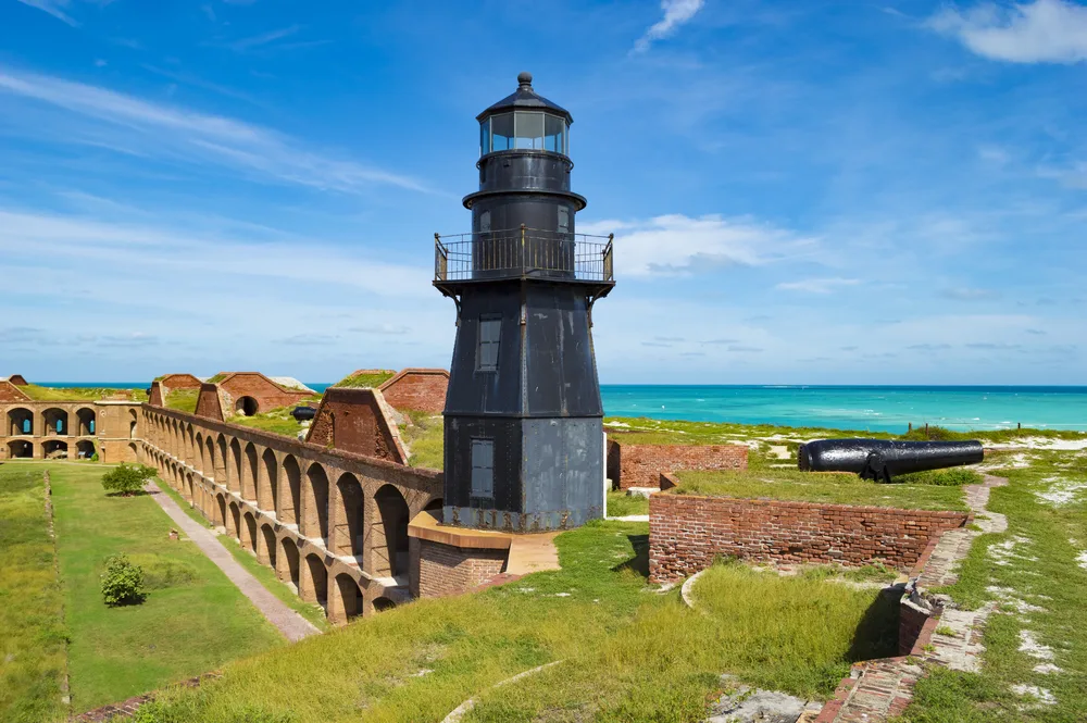 Rusting lighthouse pictured atop Fort Jefferson during the best time to visit Dry Tortugas National Park with blue skies and warm weather