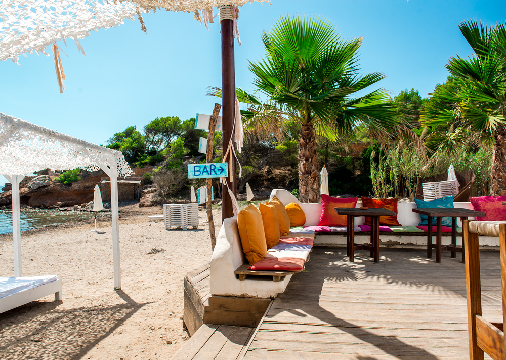 Outdoor bar with a sign that says bar pictured during the cheapest time to visit Ibiza