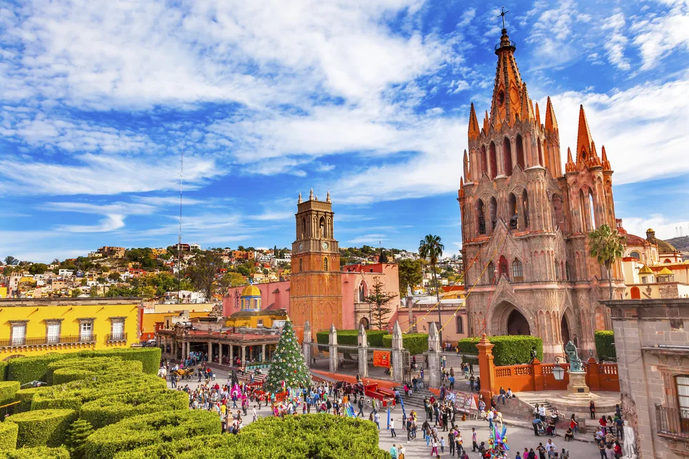 Aerial view of the Parroquia Archangel Church in Jardin Town Square pictured during the best time to visit San Miguel de Allende, with blue skies and moderate temperatures