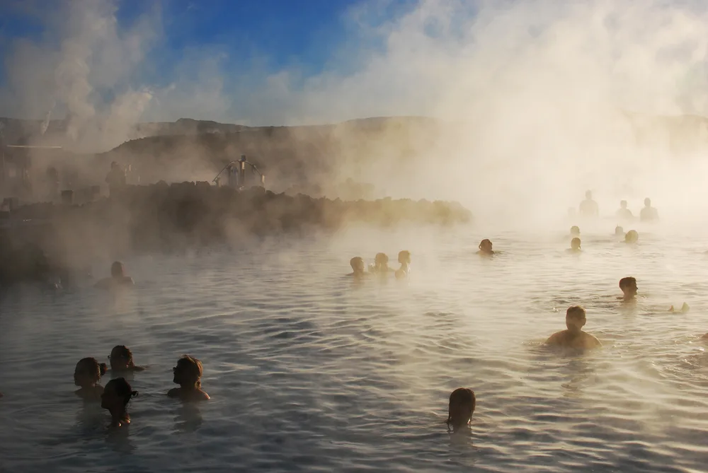 Pictured during the best time to visit the Blue Lagoon, people swimming in the pool in Iceland
