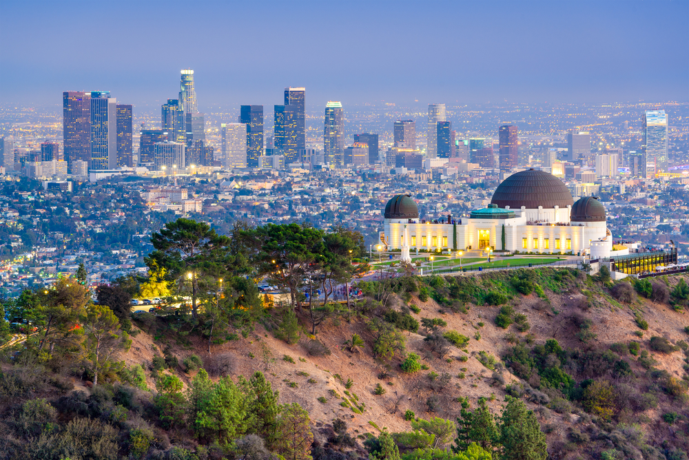 The observatory in Los Angeles, one of the best places to visit in January, pictured from Griffith Park, with the downtown skyline in the background