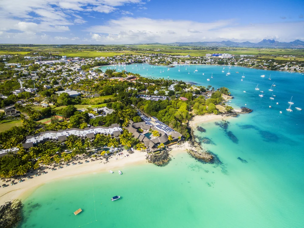 Aerial view over Mauritius beaches in Grand Baie with boats in the water and greenery surrounding for a list of the best places to visit in July