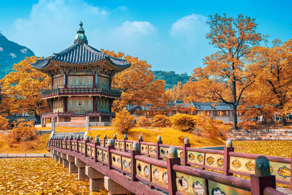 Autumn in Seoul, South Korea, one of the best places to visit in September, with golden red leaves next to a temple walking path