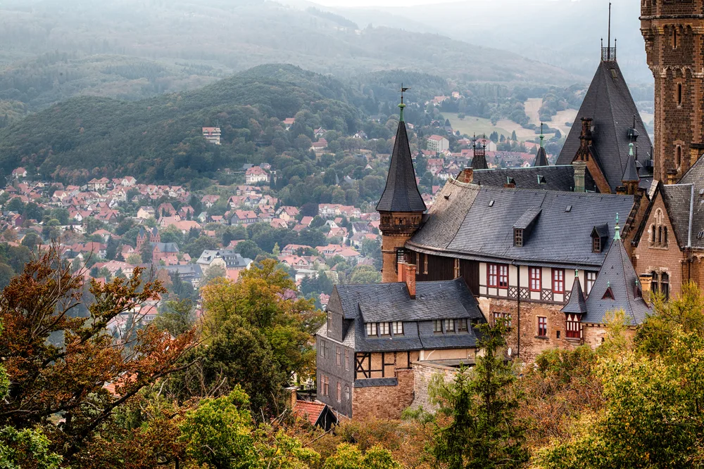 Hilltop view of the Wernigerode Castle in the Harz Mountains in Germany pictured overlooking the village below as one of the best places to visit in April