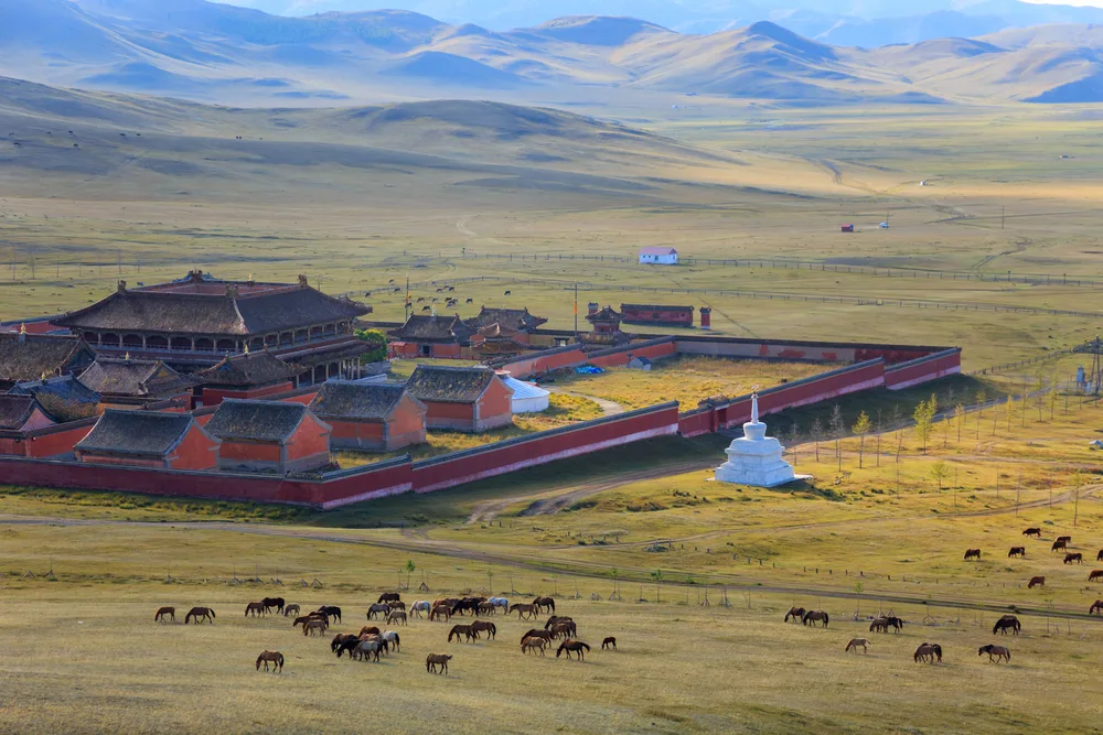 Ambarbayasgalant monastery pictured from the air with horses grazing in the fields outside the walls, as seen during the least busy time to visit Mongolia