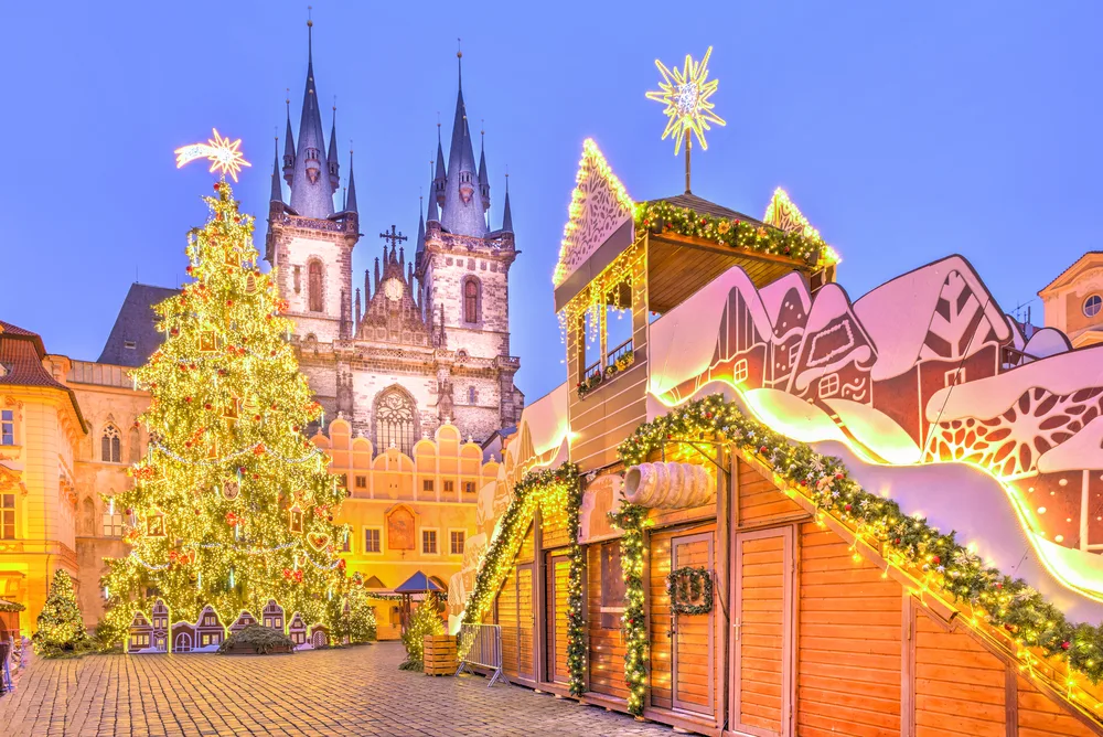 Christmas tree and fairy tale church that's extremely lit up with lights and a huge tree the size of the cathedral pictured as one of the best places to visit December