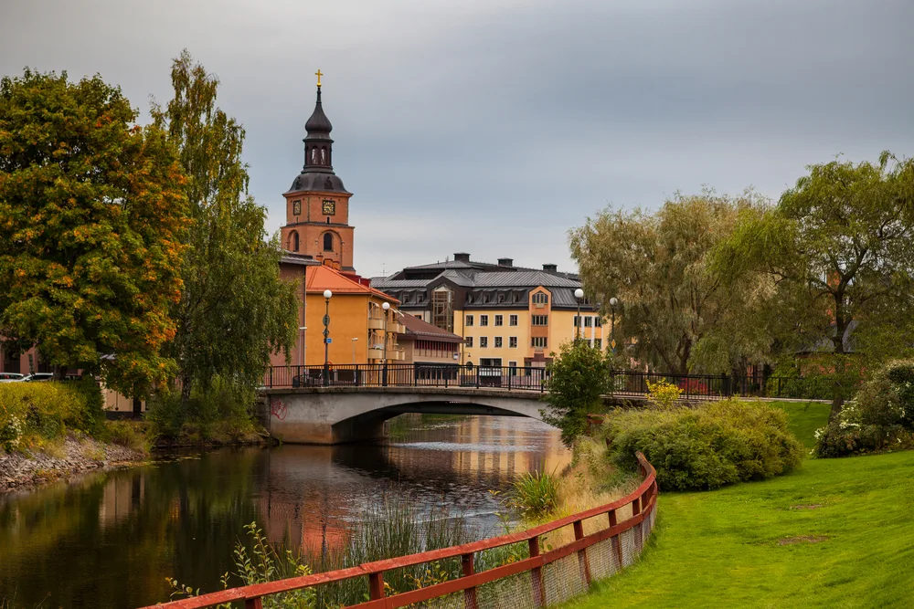 Traditional red wooden home and buildings with a river winding through the middle of the town in Falun, one of the best places to visit in Sweden