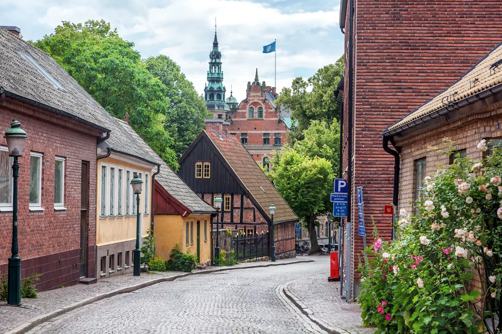 Old brick streets of Lund, one of Sweden's best places to visit, seen winding through the old homes made of brick and stucco