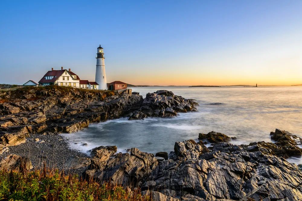 Portland Head Lighthouse pictured at dusk in autumn in a roundup of the best places to visit in October