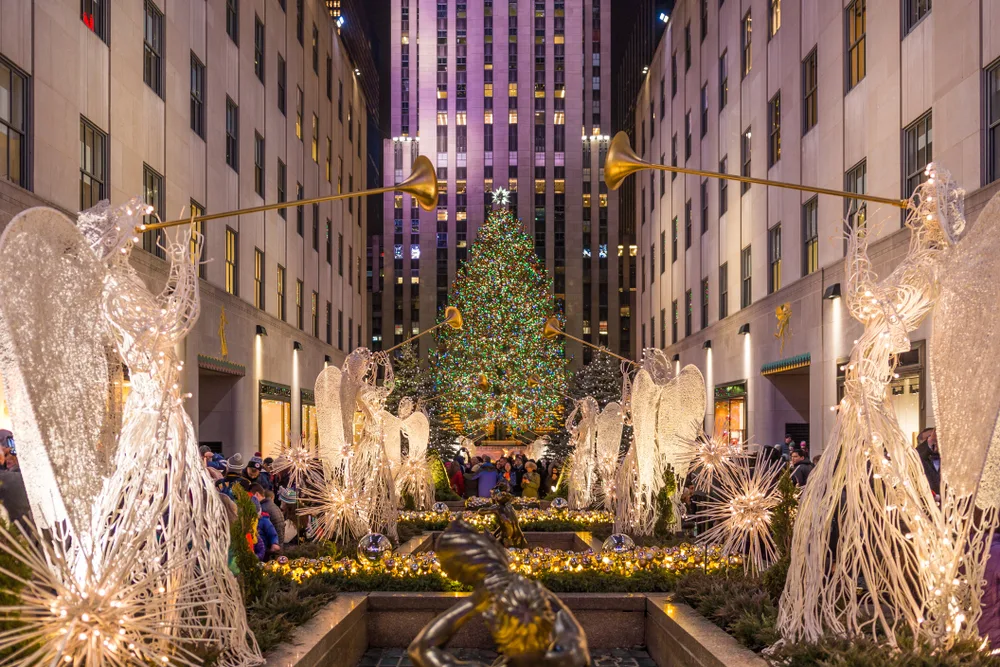Angels below the light-up Christmas tree in Rockefeller Center pictured as one of the best places to visit in December