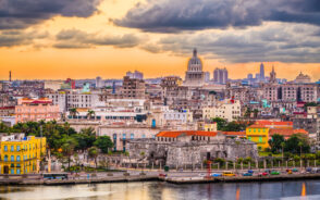 View of the Havana, Cuba skyline at dusk with clouds over the city for a piece explaining how Americans can travel to Cuba
