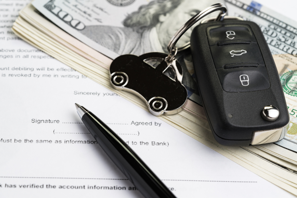 Rental car agreement with keys and pen lying on top for a frequently asked questions section about the cheapest ways to rent a car