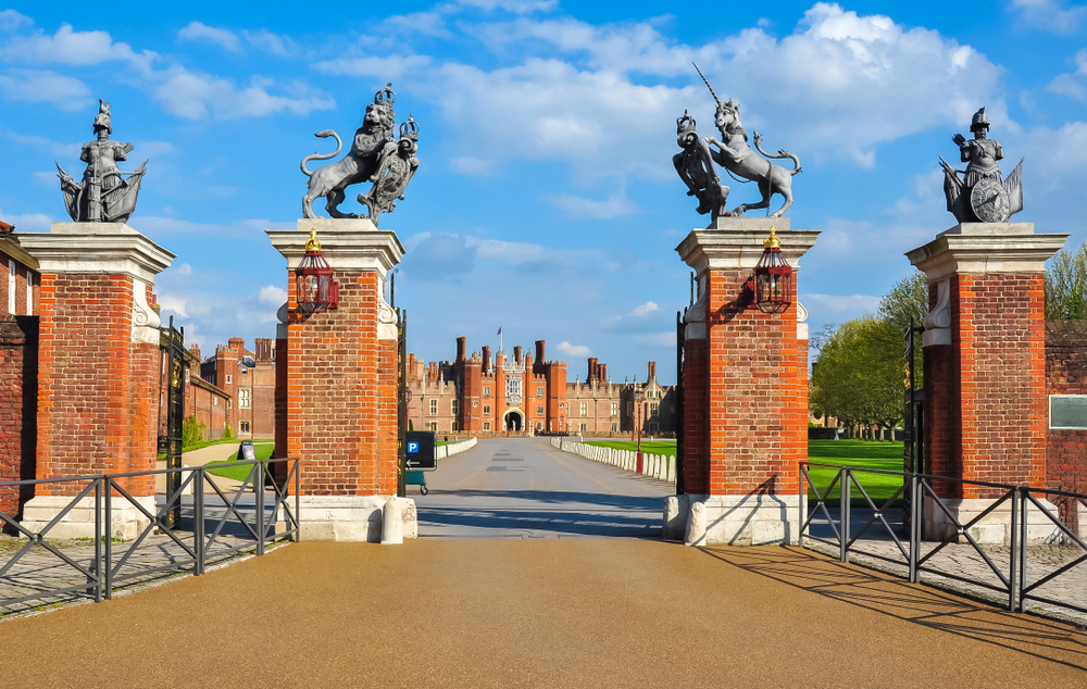 Red brick entrance to Hampton Court, one of the best day trips to take from London, with its red brick gates leading to the main building
