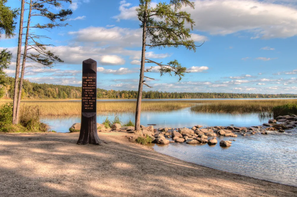 Stone monument marking the headwater of the Mississippi River, as seen from the banks of the lake in Itasca State Park