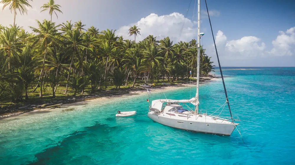 White sailing yacht in the San Blas islands, a top pick for where to visit in Panama, with the boat floating on the crystal-clear water
