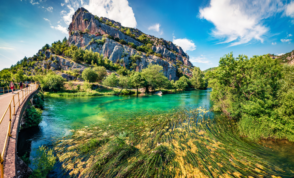 Breathtaking view of the ragged mountain overlooking the teal water at Krka National Park, one of Croatia's best places to visit