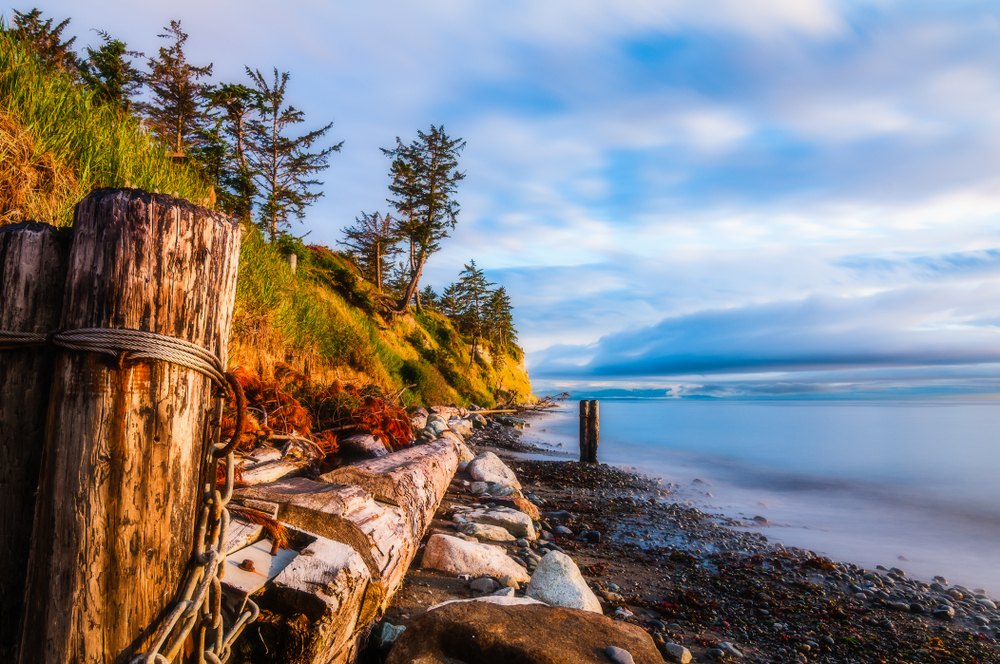 Abandoned and rickety wooden pier on the rocky coast of Whidbey Island, a great day trip from Seattle