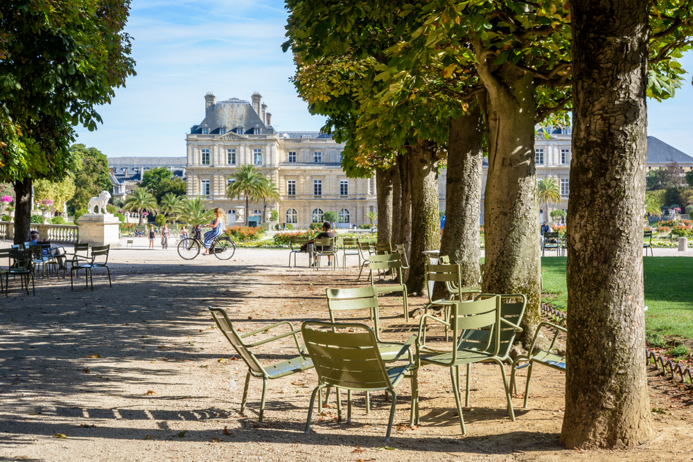 For a roundup of the best places to visit in Paris, a small table with metal chairs pictured in the Luxembourg Garden